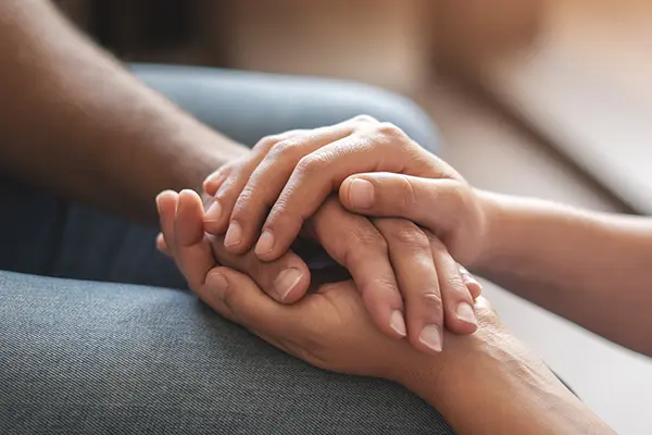 Someone holding another's hand in comfort